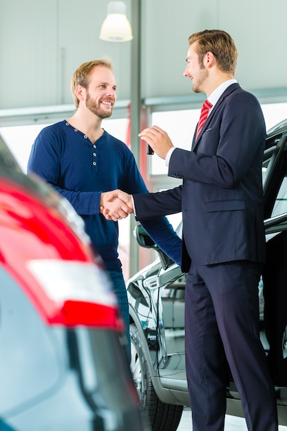 Young Man And Seller With Auto In Car Dealership Stock Image Image Of